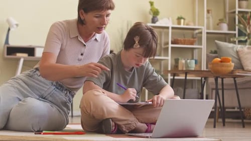 Woman Helping Teen Girl with Homework at Home