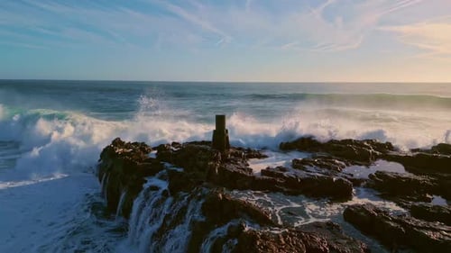 Powerful Ocean Waves Crashing Against Rocky Shore at Golden Sunset