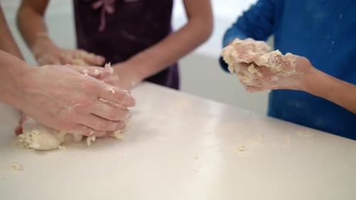 Mutterhände beim Kochen mit Kindern. Nahaufnahme einer Familie, die gemeinsam Teig kocht. Mama unterrichtet K...