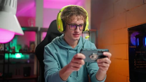 Young Adult Male Gamer Playing Mobile Game