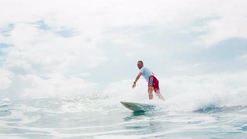 Surfer rides the wave in the ocean in the Maldives