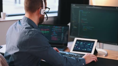 Programmer is working in the modern office. Sitting by computer