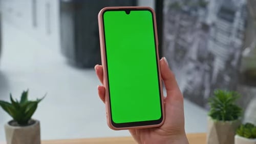 Woman Tapping Smartphone with Green Screen Display
