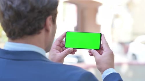 Businessman Holding Phone with Green Screen Outdoor