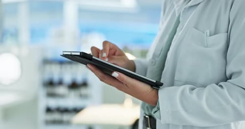Person in Lab Coat Using Tablet in Lab