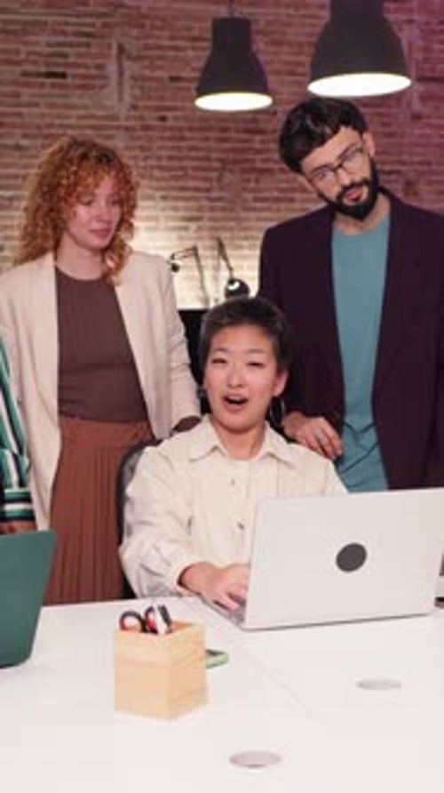Team Collaborates on Laptop in Modern Office