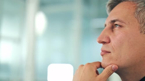 Thoughtful Businessman in Office Reflecting on Work Strategy