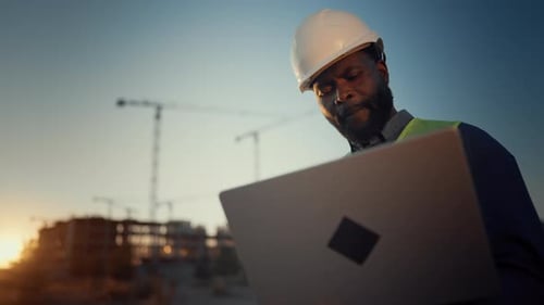 Focused African Foreman Looking at Laptop Display at Construction Site Portrait of Black