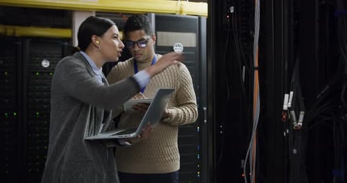 Two Young Adults Working on Servers