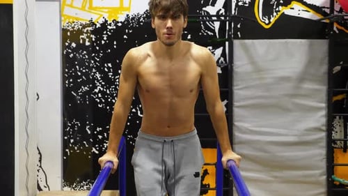 Strong Sporty Man Doing Push Ups on Parallel Bars at Modern Gym Young Sportsman Exercising at