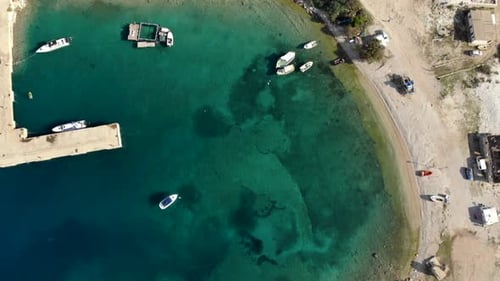 Sea bay with turquoise calm water of Mediterranean and anchored fishing boats near pier