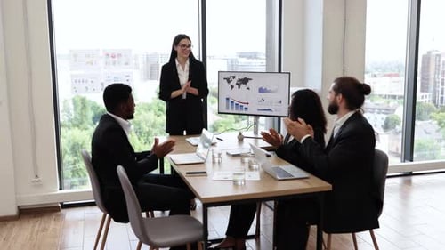 Businesswoman Presenting Report to Diverse Colleagues in Modern Office