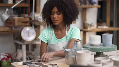 Young women is making earthenware at workshop.