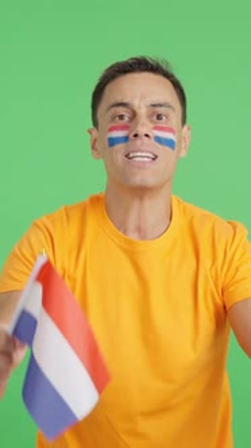 Man in Orange Shirt Waving Flag, Expressing Emotion