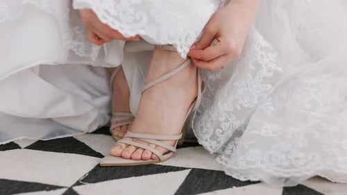 Bride Fastening Strappy High Heels on Wedding Day