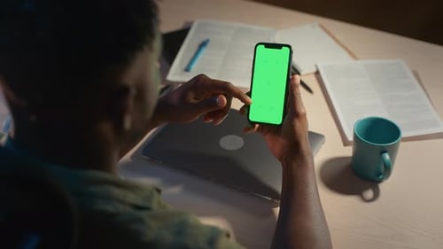 Freelancer Holding Smartphone with Chroma Key Screen at Home