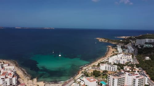 Aerial drone footage of the town of Sant Antoni de Portmany on the west coast of Ibiza in Spain