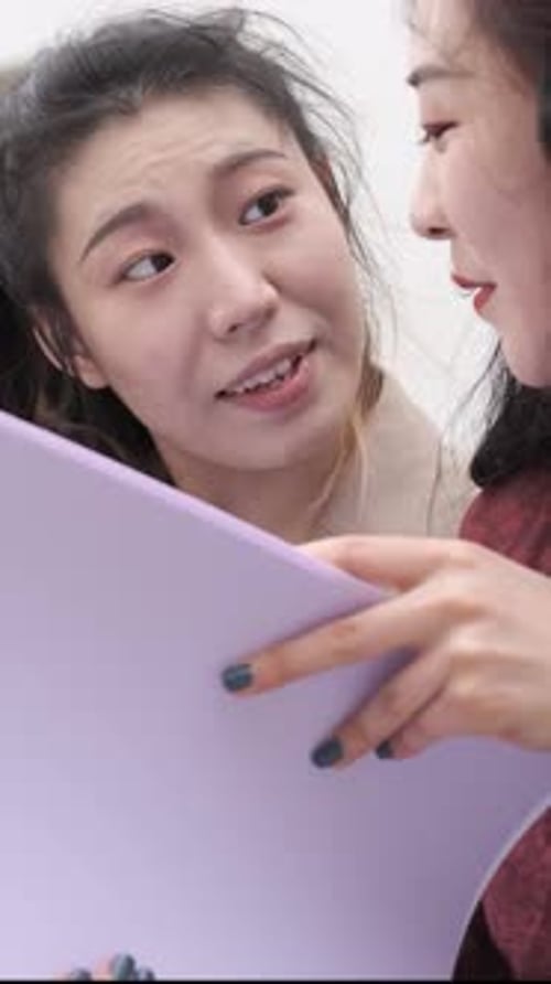 Porträt zweier asiatischer Studentinnen, die in der Pause auf dem Campus sitzen