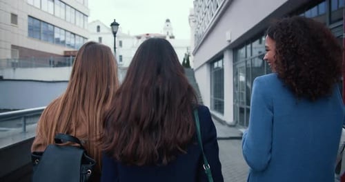 Camera Follows Three Beautiful Young Multiethnic Business Women Walking Together in City Downtown on