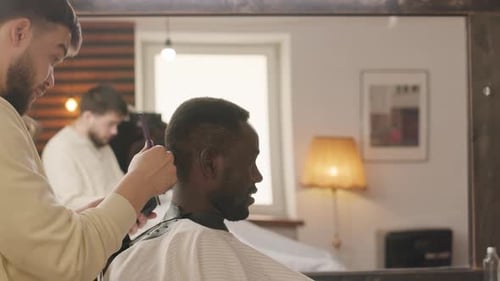 Barber Cuts Man's Hair in Modern Barbershop