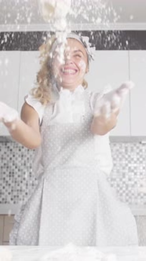 Woman Tossing Flour in Kitchen with Joy