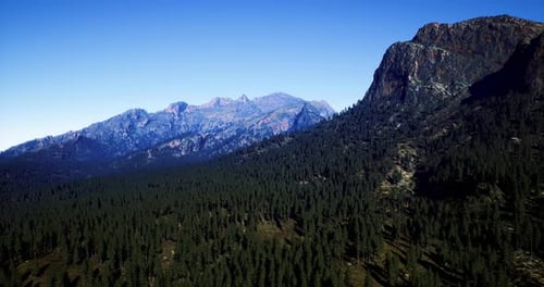 Majestic Mountain Landscape with Lush Green Forests Under a Clear Blue Sky