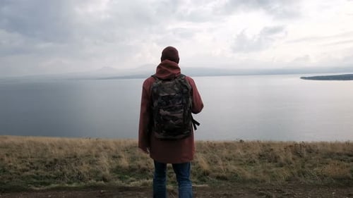 Lone Hiker Overlooking Expansive Lake Landscape