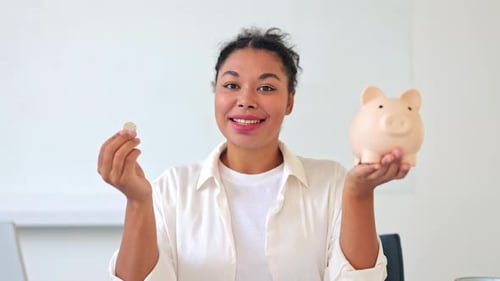 Confident Businesswoman Saving Money in Piggy Bank