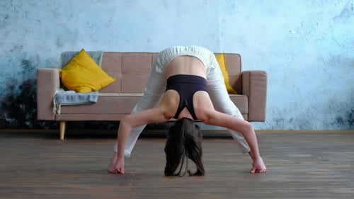Maître de yoga, femme faisant des poses à la maison, Prasarita Padottanasana