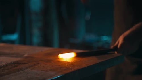 Blacksmith Shaping Hot Metal at Industrial Workbench