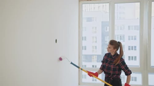 Woman Painting White Wall with Paint Roller