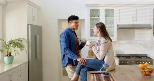 Couple Drinking Coffee and Talking in Kitchen