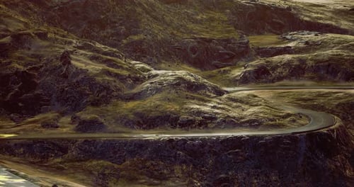Curved Road Winding Through Vast Rocky Landscape Under Golden Light