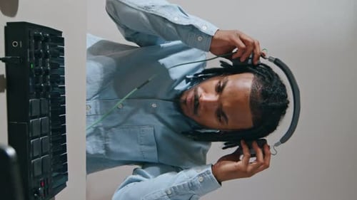 Young Adult Putting on Headphones Indoors