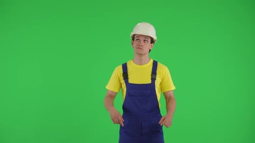 Medium Green Screen Isolated Chroma Key Video of a Young Construction Worker Looking at the Top of