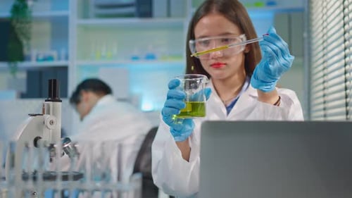 Young Woman Scientist Conducting Experiment in Laboratory