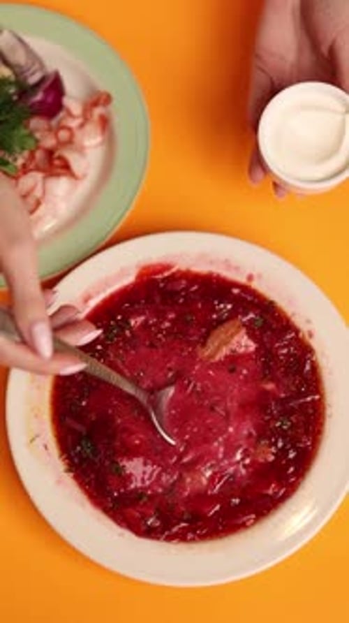 Un plato de borsch ucraniano sobre un fondo naranja