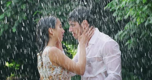 Couple Embraces and Kisses in the Rain