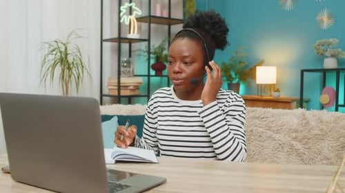 Young Woman Teleconferencing, Working at Laptop in Apartment
