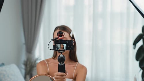 Woman Recording Makeup Tutorial in Bright Bedroom