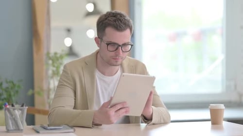 Joyeux jeune homme d'affaires utilisant une tablette PC