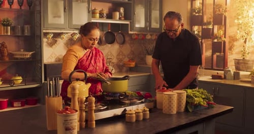 Man and Woman Cooking Food Together in Kitchen