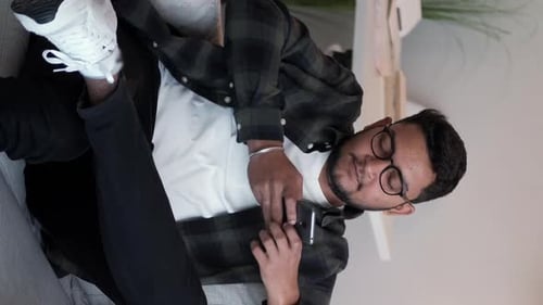 Young Adult Relaxing on Couch with Phone