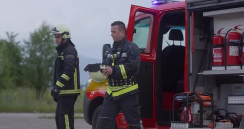 Firefighters in Protective Gear Near Fire Truck