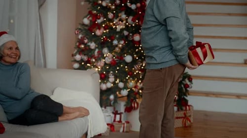 Senior Couple Exchanging Christmas Gifts at Home