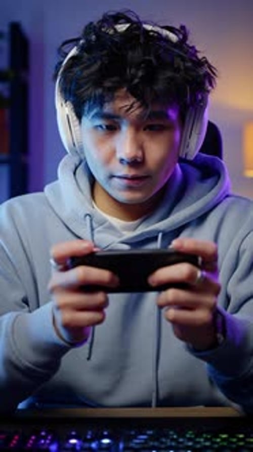 Intense Man Playing Game on Mobile Phone