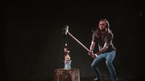 Man Smashes Burning Figurine with Sledgehammer in Slow Motion