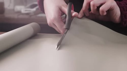 A Creative Craft Cutting Paper with Scissors and a Young Woman in a Flower Shop