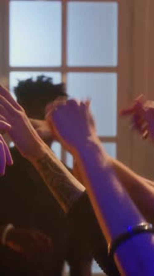 Excited Friends Raise Hands Together at Party
