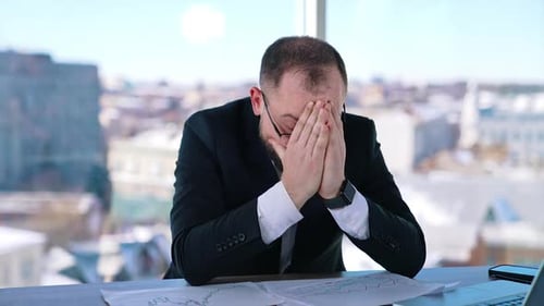Un homme d'affaires déprimé est assis au bureau